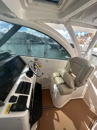 No Name Yacht Photos Pics 2019 Pursuit OS 385 Offshore helm with leather seat, steering wheel, and control panel.