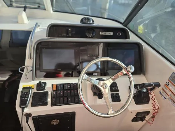 No Name Yacht Photos Pics 2019 Pursuit OS 385 Offshore boat dashboard with steering wheel and navigation controls.