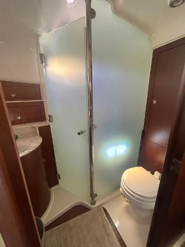 No Name Yacht Photos Pics 2019 Pursuit OS 385 Offshore bathroom with shower, sink, and toilet.
