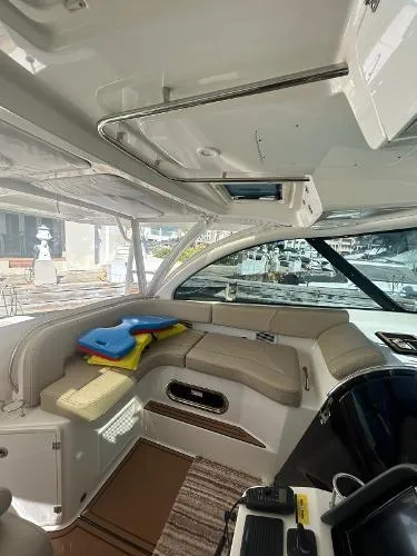 No Name Yacht Photos Pics 2019 Pursuit OS 385 Offshore interior with beige seating and colorful cushions.
