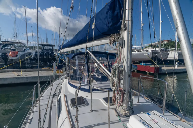 4 Knots Yacht Photos Pics Hylas 51 sailboat from 1990 docked at marina, clear sky background.