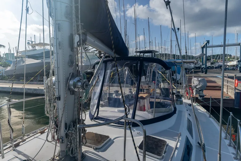4 Knots Yacht Photos Pics Hylas 51 sailboat from 1990 docked at a marina under a cloudy sky.