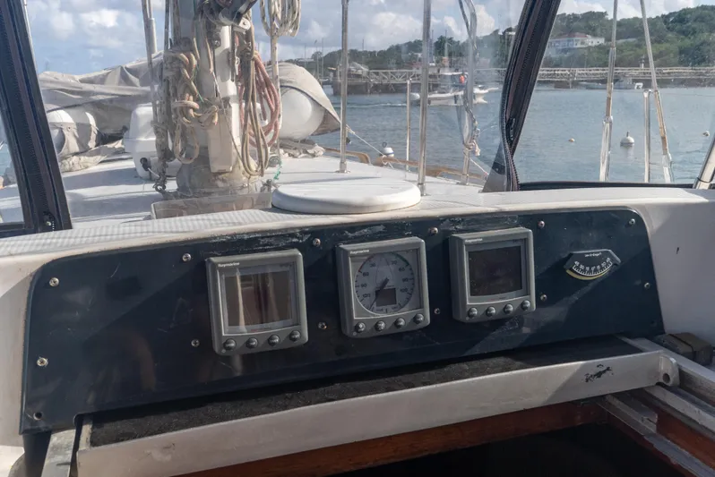 4 Knots Yacht Photos Pics Cockpit of 1990 Hylas 51 sailboat with navigation instruments and scenic harbor view.