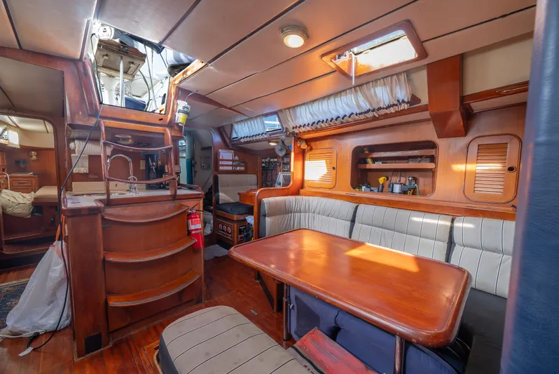 4 Knots Yacht Photos Pics Interior of a 1990 Hylas 51 yacht with wood finishes and cozy seating area.