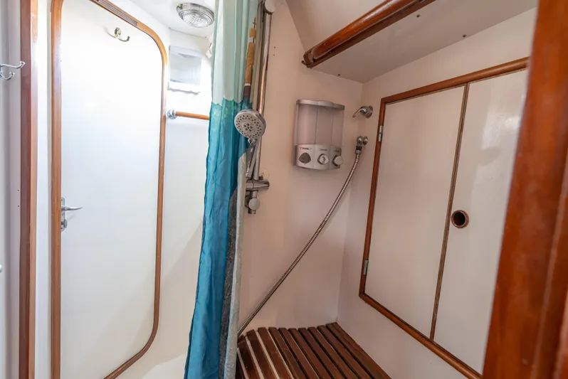 4 Knots Yacht Photos Pics Shower area in 1990 Hylas 51 yacht with wooden accents and modern fixtures.