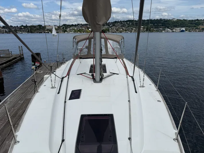 Kahuna Yacht Photos Pics Sailboat Jeanneau 409, 2011 model, docked by a scenic waterfront with distant sailboats.