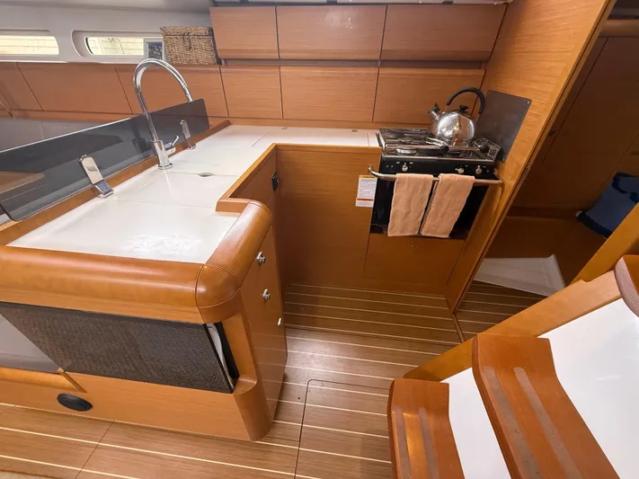 Kahuna Yacht Photos Pics 2011 Jeanneau 409 yacht kitchen with wooden cabinetry, stove, and sink.