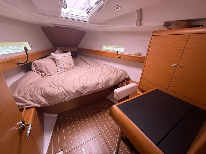 Kahuna Yacht Photos Pics Cozy cabin interior of 2011 Jeanneau 409 sailboat with wood finish and comfortable bedding.