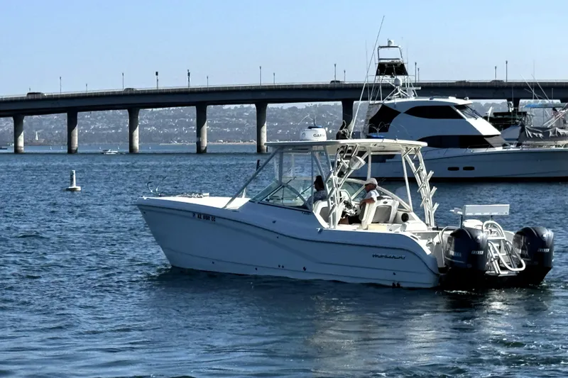  Yacht Photos Pics 2017 World Cat 295 DC boat cruising near a bridge with other yachts.
