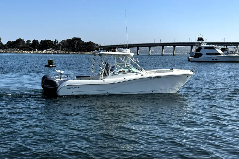  Yacht Photos Pics 2017 World Cat 295 DC boat cruising on a sunny day near a bridge.