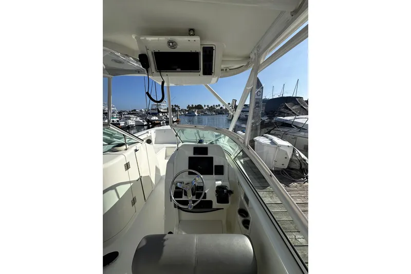  Yacht Photos Pics Interior view of 2017 World Cat 295 DC boat at marina, featuring steering console and docked boats.