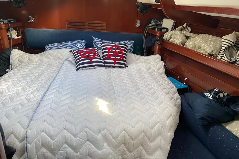 Milos Dream Yacht Photos Pics Cozy cabin interior of 2003 Beneteau Oceanis 50 with nautical-themed bedding.