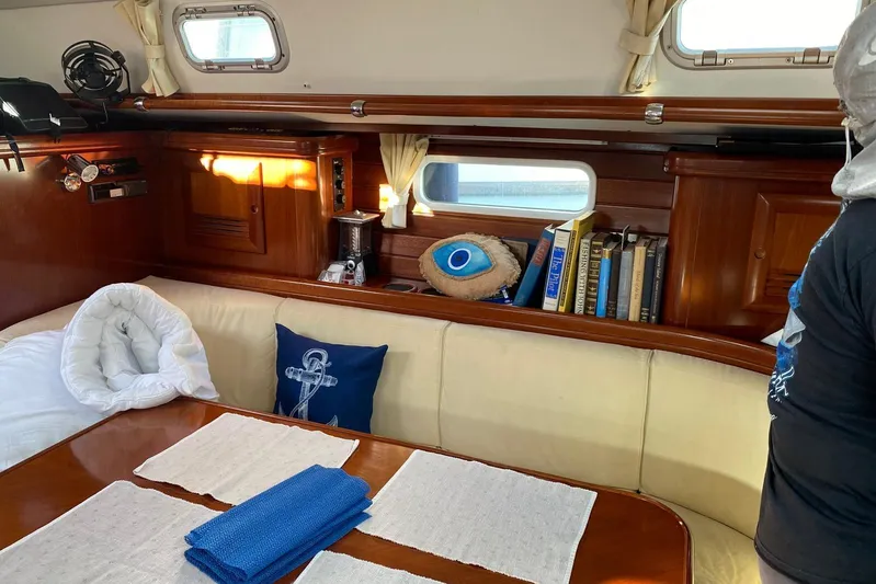 Milos Dream Yacht Photos Pics Cozy interior of 2003 Beneteau Oceanis 50 sailboat with books and nautical decor.