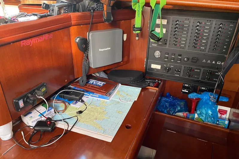 Milos Dream Yacht Photos Pics Navigation station on 2003 Beneteau Oceanis 50 yacht with Raymarine equipment and nautical charts.