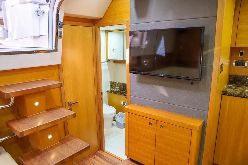 Aquaholic Yacht Photos Pics 2013 Sunseeker Portafino yacht interior with wooden stairs, TV, and bathroom.