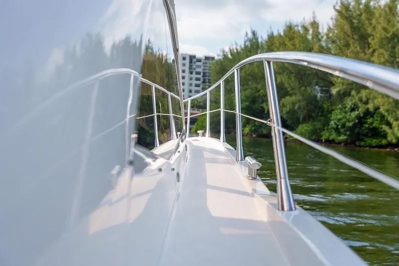 Aquaholic Yacht Photos Pics 2013 Sunseeker Portafino yacht deck with railing, surrounded by lush greenery and water.