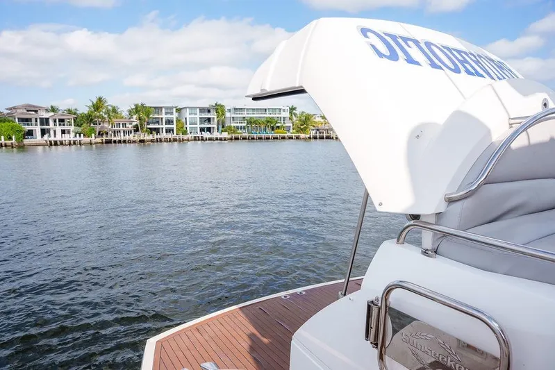 Aquaholic Yacht Photos Pics 2013 Sunseeker Portafino yacht on calm water with luxury waterfront homes in background.