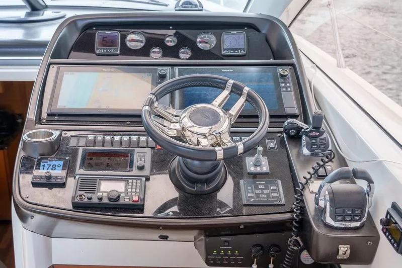 Aquaholic Yacht Photos Pics Cockpit of 2013 Sunseeker Portafino yacht with navigation controls and steering wheel.