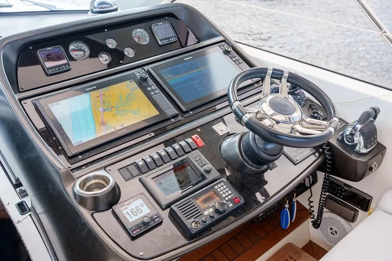 Aquaholic Yacht Photos Pics Cockpit of 2013 Sunseeker Portafino yacht with navigation screens and steering wheel.