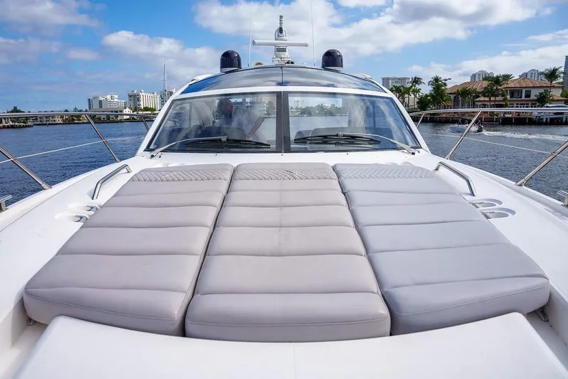 Aquaholic Yacht Photos Pics 2013 Sunseeker Portafino yacht with sunbathing deck, docked near waterfront buildings.