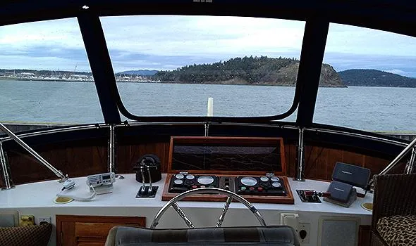 Hullabaloo Yacht Photos Pics Pilothouse view from 1986 Sea Ranger 47, overlooking calm waters and distant shoreline.