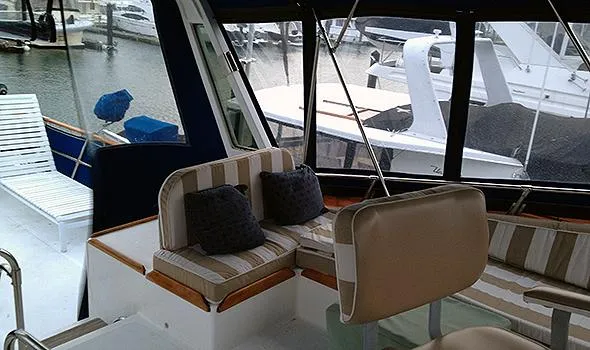 Hullabaloo Yacht Photos Pics 1986 Sea Ranger 47 Pilothouse interior with striped seating and marina view.