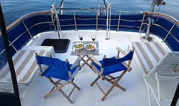 Hullabaloo Yacht Photos Pics Deck of 1986 Sea Ranger 47 Pilothouse with chairs, table, and meals.