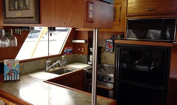 Hullabaloo Yacht Photos Pics 1986 Sea Ranger 47 Pilothouse kitchen with granite countertops, stove, and microwave.