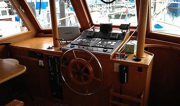 Hullabaloo Yacht Photos Pics 1986 Sea Ranger 47 Pilothouse interior with wooden helm and navigation controls.