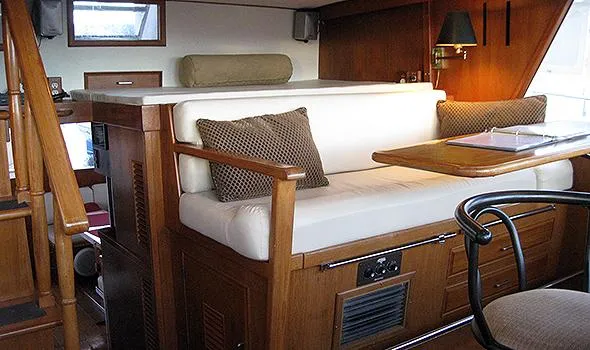 Hullabaloo Yacht Photos Pics Interior of 1986 Sea Ranger 47 Pilothouse with wooden furnishings and cushioned seating.
