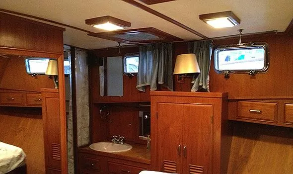 Hullabaloo Yacht Photos Pics 1986 Sea Ranger 47 Pilothouse interior with wood paneling, sink, and porthole windows.