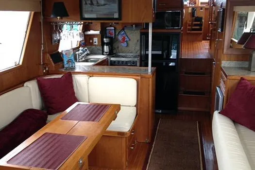 Hullabaloo Yacht Photos Pics Interior of 1986 Sea Ranger 47 Pilothouse with cozy seating and wooden finishes.