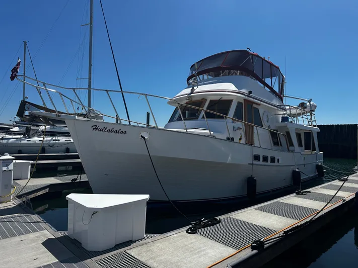 Hullabaloo Yacht Photos Pics 1986 Sea Ranger 47 Pilothouse yacht docked at marina under clear blue sky.