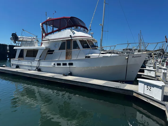 Hullabaloo Yacht Photos Pics 1986 Sea Ranger 47 Pilothouse yacht docked at marina under clear blue sky.