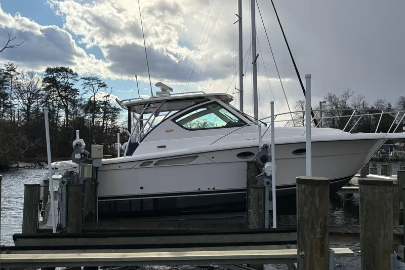  Yacht Photos Pics 2008 Tiara Yachts 3000 Open docked, surrounded by trees and cloudy sky.