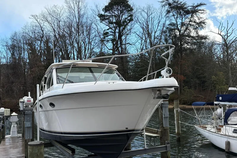  Yacht Photos Pics 2008 Tiara Yachts 3000 Open docked, surrounded by trees and calm water.