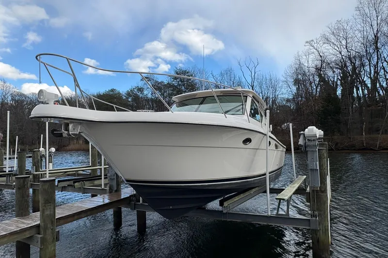  Yacht Photos Pics 2008 Tiara Yachts 3000 Open on a lift at a dock, under a cloudy sky.