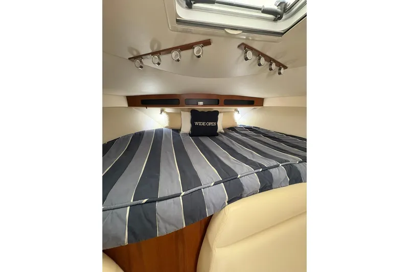 Yacht Photos Pics 2008 Tiara Yachts 3000 Open cabin with striped bedding and overhead lighting.