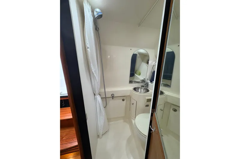  Yacht Photos Pics Compact bathroom in 2008 Tiara Yachts 3000 Open, featuring shower, sink, and toilet.