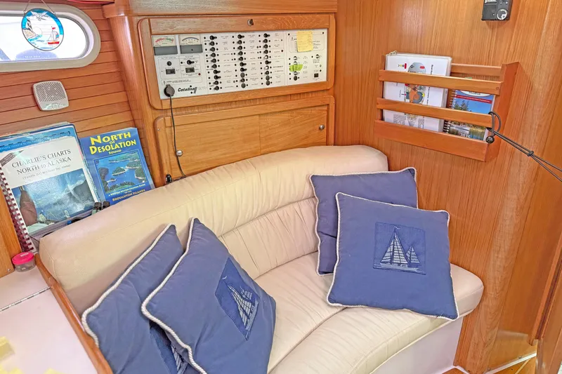 Shumka Yacht Photos Pics Cozy interior of 2005 Catalina 42 MkII sailboat with navigation books and nautical-themed pillows.