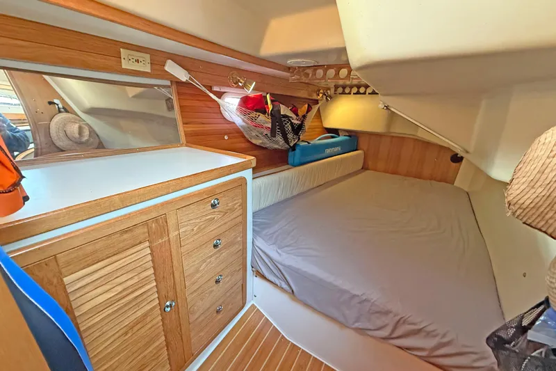 Shumka Yacht Photos Pics Cozy cabin interior of 2005 Catalina 42 MkII sailboat with wooden cabinetry and bed.