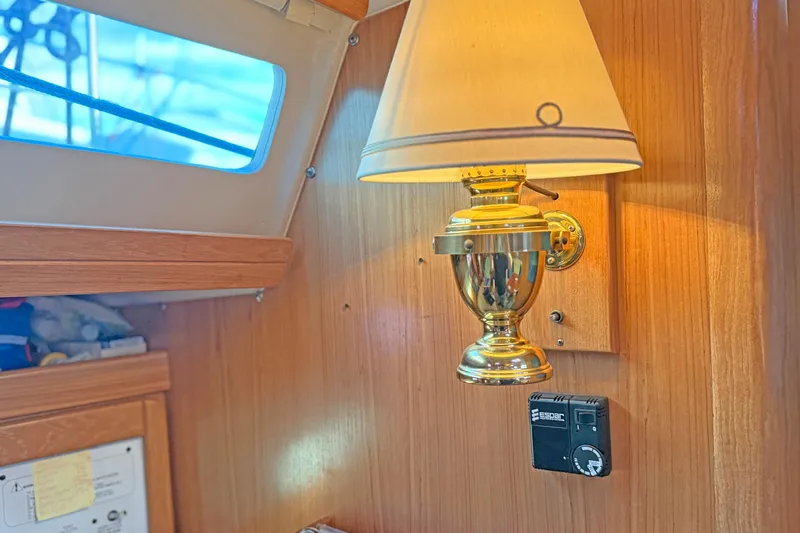 Shumka Yacht Photos Pics Interior of 2005 Catalina 42 MkII yacht with brass wall lamp and wooden paneling.