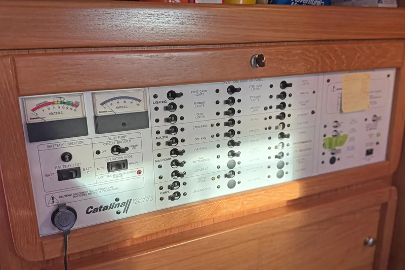 Shumka Yacht Photos Pics Electrical control panel of a 2005 Catalina 42 MkII yacht, featuring gauges and switches.