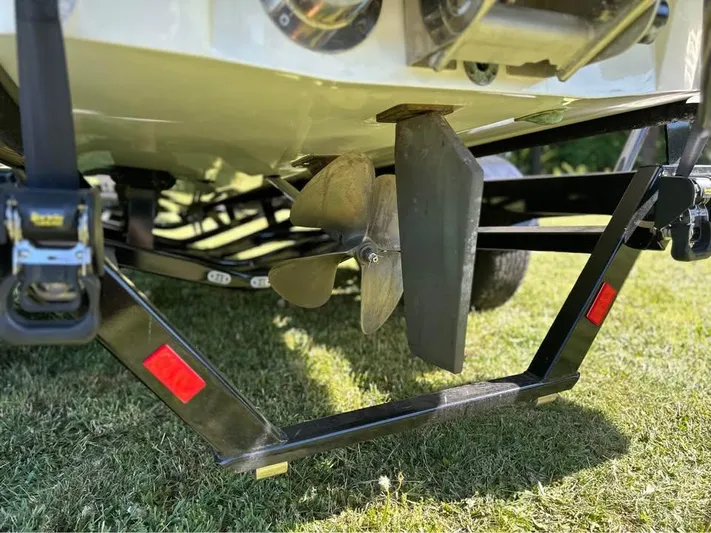  Yacht Photos Pics Close-up of 2023 Malibu Wakesetter 23 MXZ propeller and trailer on grass.
