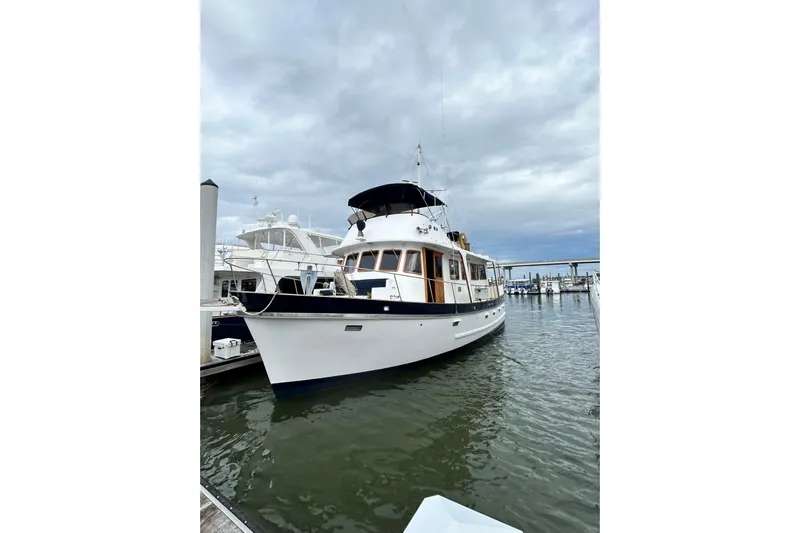 Savasa Yacht Photos Pics 1979 Cheoy Lee 46 LRC yacht docked at marina under cloudy sky.