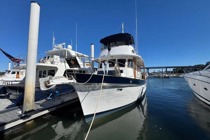 Savasa Yacht Photos Pics 1979 Cheoy Lee 46 LRC yacht docked, for sale, under clear blue sky.