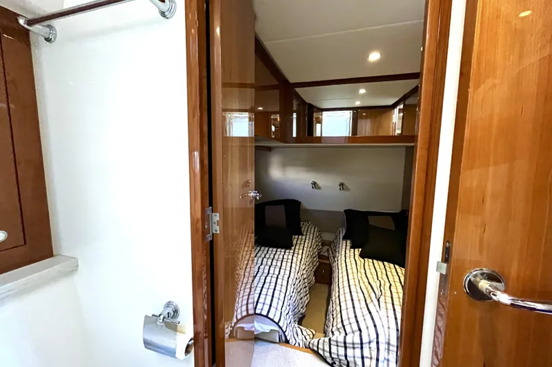 Yacht-o-fun Yacht Photos Pics Interior of 2014 Riviera 5800 Sport Yacht with twin beds and wooden finishes.