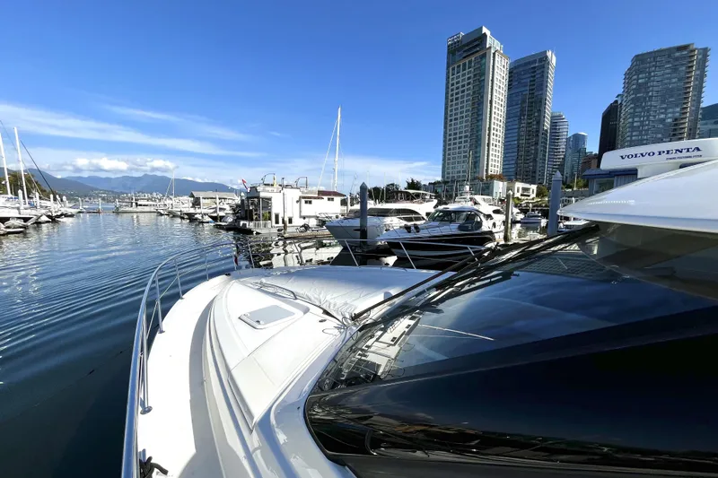 Yacht-o-fun Yacht Photos Pics 2014 Riviera 5800 Sport Yacht docked in urban marina with skyscrapers.