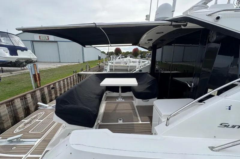 Floor It Yacht Photos Pics 2014 Sea Ray 510 Sundancer yacht with covered seating area and table at dock.