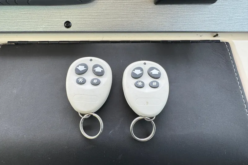 Floor It Yacht Photos Pics Two remote controls for a 2014 Sea Ray 510 Sundancer boat on a black surface.